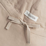 Detail view of beige linen baby sun hat with adjustable tie and SoLoveAble label, close-up