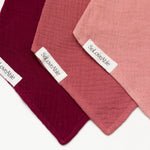 Cotton baby bib set in berry tones with snap buttons - close-up
