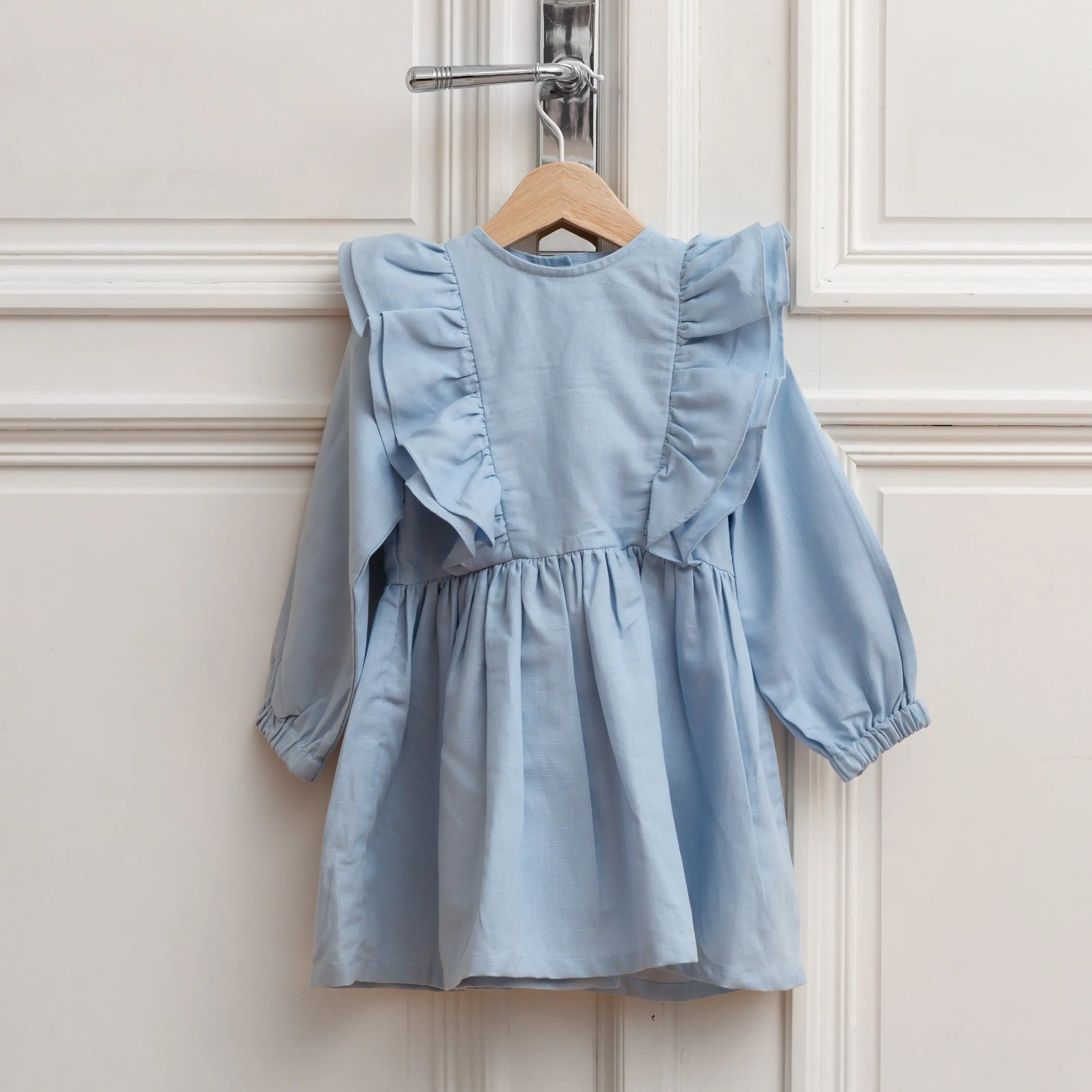 Ruffled blue linen girls dress with long sleeves, front view on hanger, elegant style for special occasions