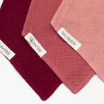 Soloveable close-up of muslin baby bandana bibs in pink, red and burgundy