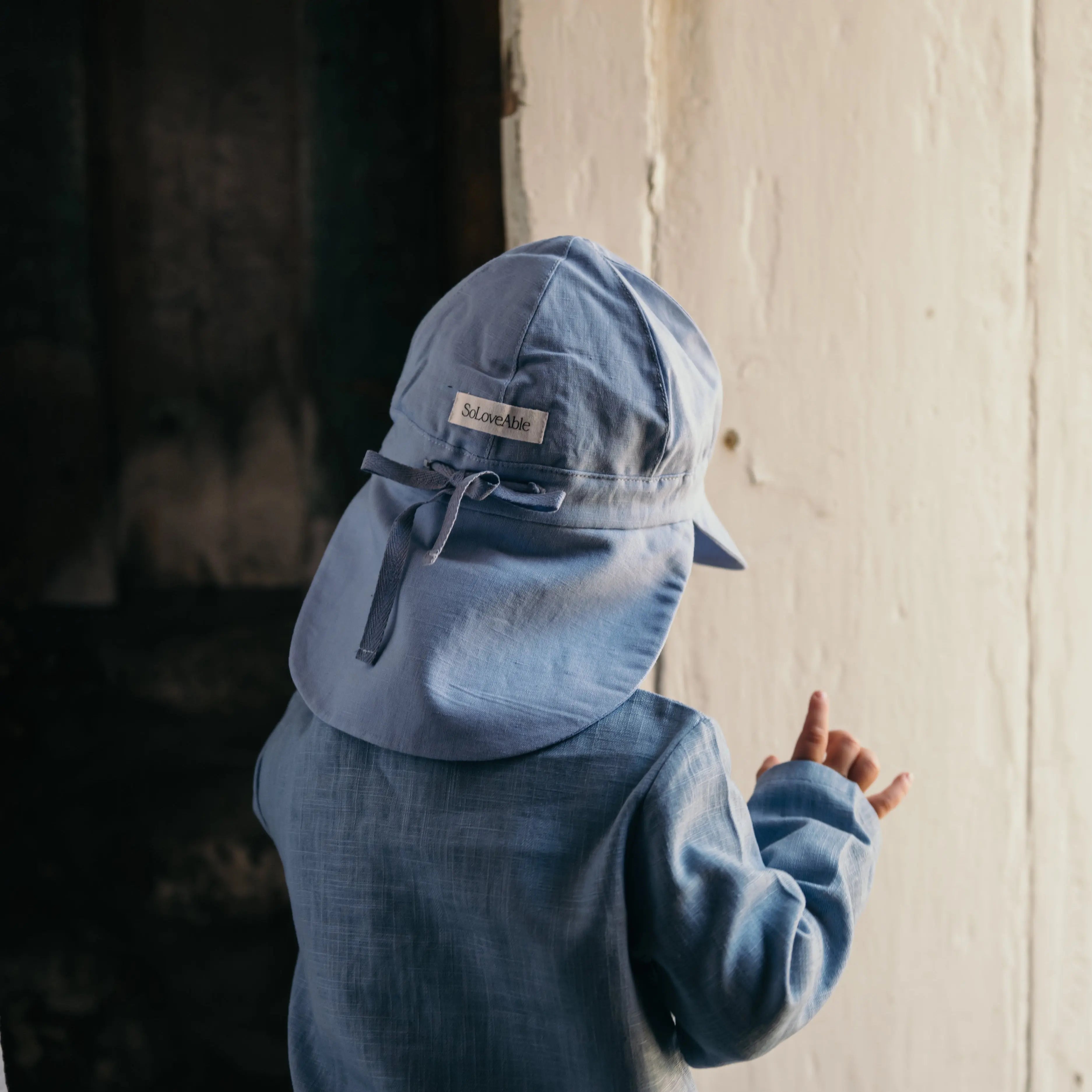 Blauer Leinenhut mit Bindeband – Rückansicht am Baby