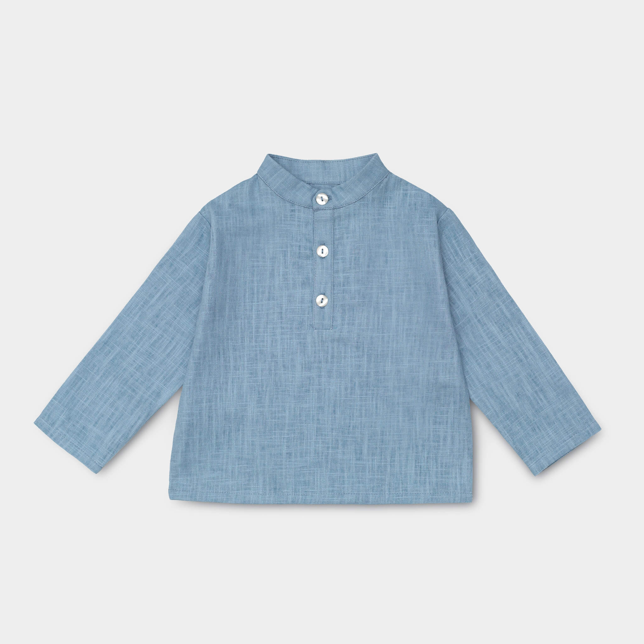 Front view of long-sleeve blue linen shirt for babies and toddlers with a collarless design and three-button placket.