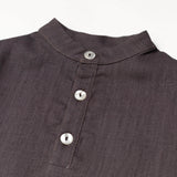 Close-up of the collarless neckline and button placket on the brown linen baby and toddler long-sleeve shirt.
