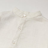 Close-up of the collarless neckline and button placket on the white linen baby and toddler long-sleeve shirt.