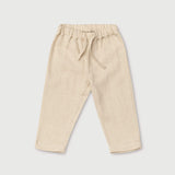Front view of long beige linen pants for babies and toddlers with elastic waistband and drawstring.