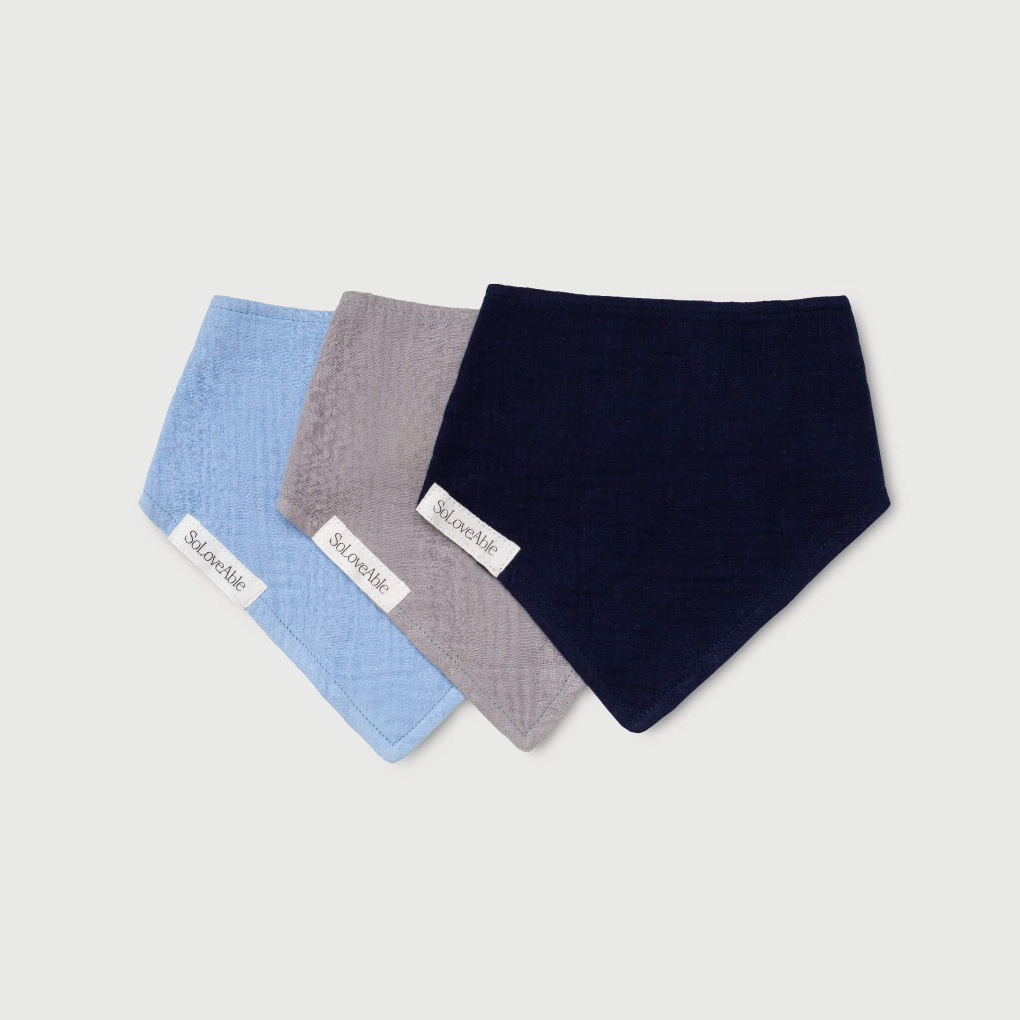 Soloveable organic muslin bandana bibs in blue, grey and navy.
