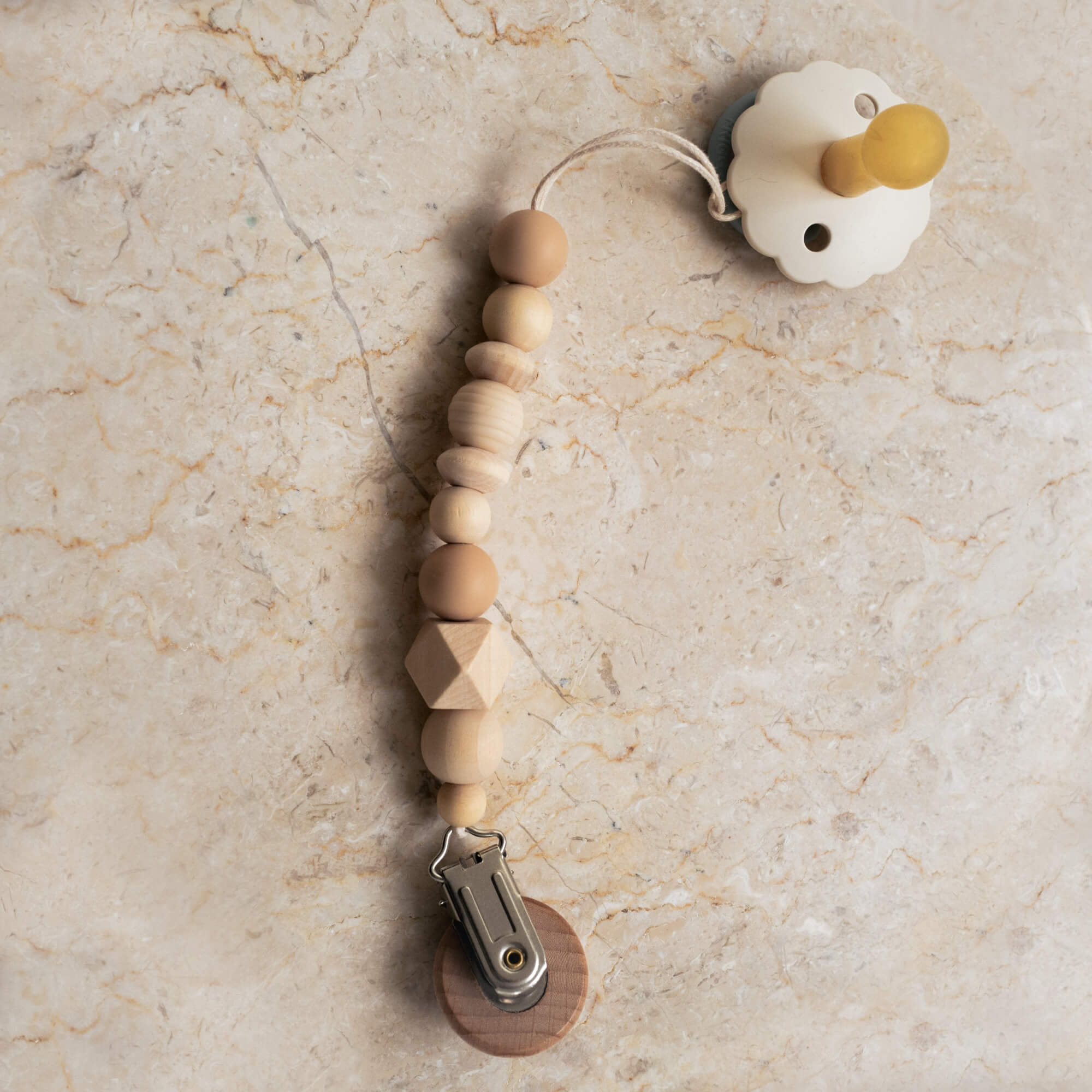 Beige silicone and wood pacifier clip with natural bead design.