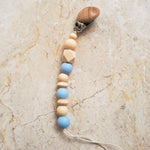 Blue silicone and natural wood pacifier clip with smooth and ribbed beads.