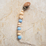 Blue silicone and natural wood pacifier clip with smooth and ribbed beads.