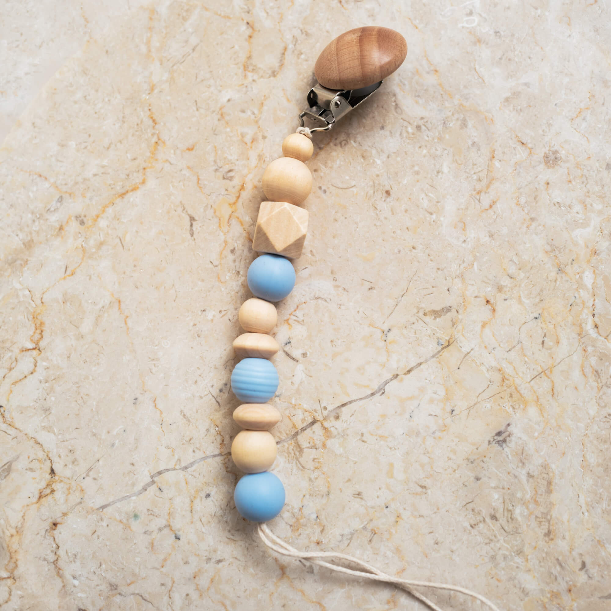 Blue silicone and natural wood pacifier clip with smooth and ribbed beads.