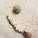 Green silicone and wood pacifier clip with natural wooden beads.