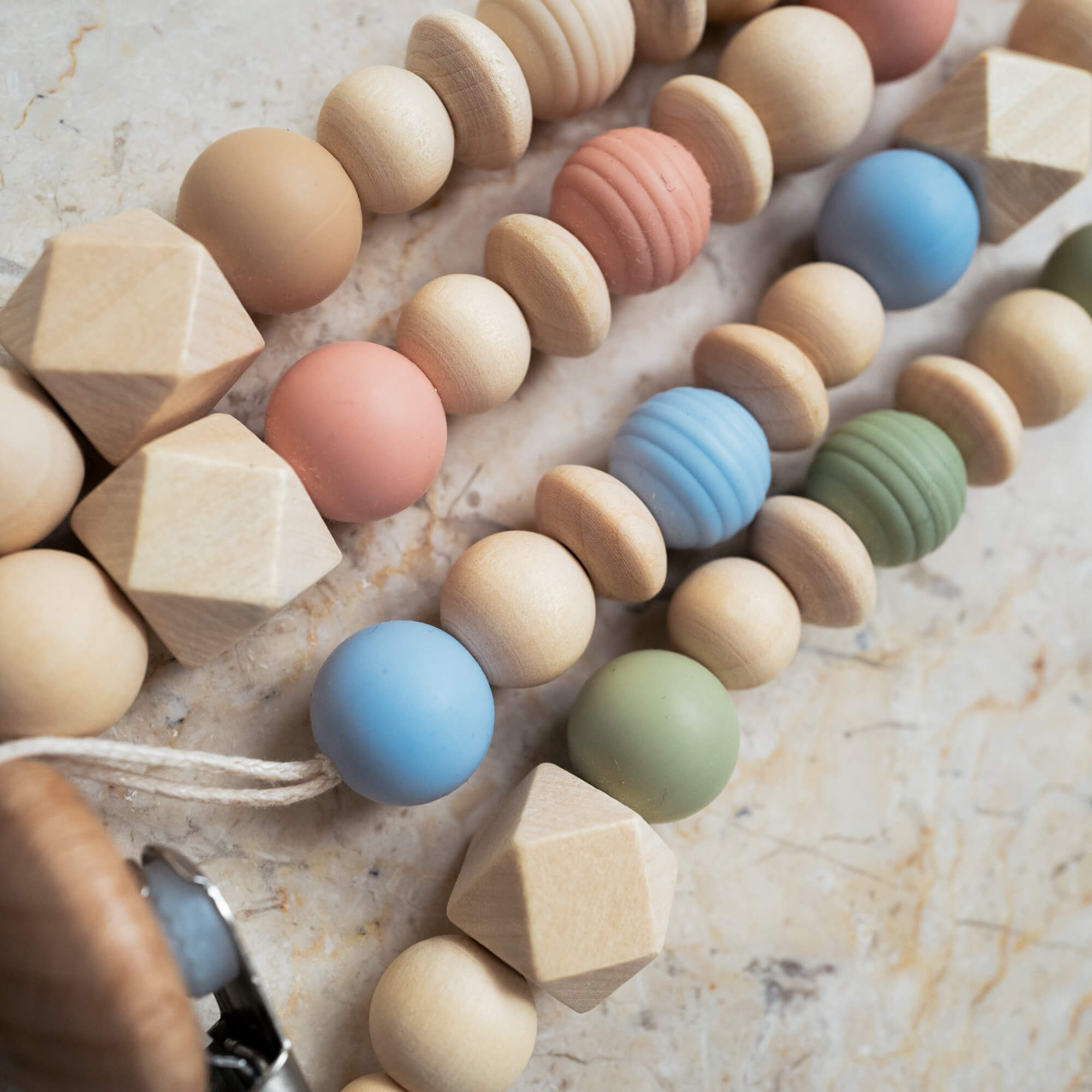 Close-up of silicone and wooden beads used in the handmade pacifier clip.