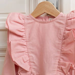 Close-up of pink linen kids linen dress with ruffle shoulder detail