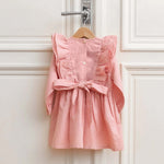 Back view of pink linen girls dress with bow and ruffle details