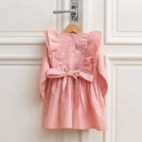 Back view of pink linen girls dress with bow and ruffle details