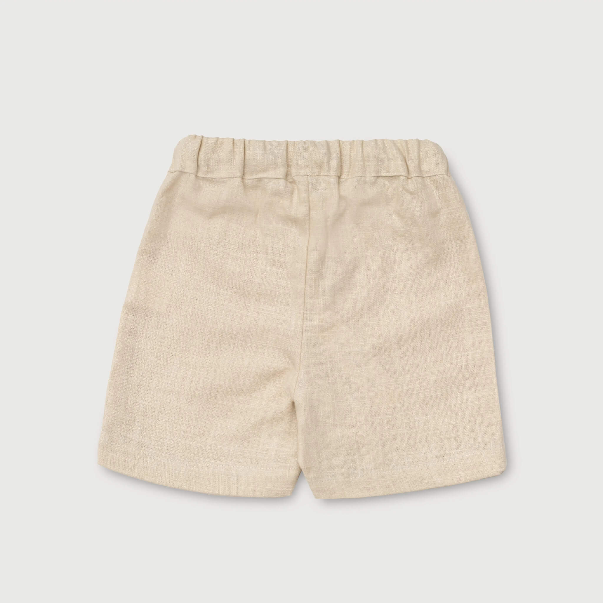 Back view of lightweight short beige linen pants for babies and toddlers.
