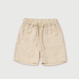 Front view of short beige linen pants for babies and toddlers with elastic waistband and drawstring.