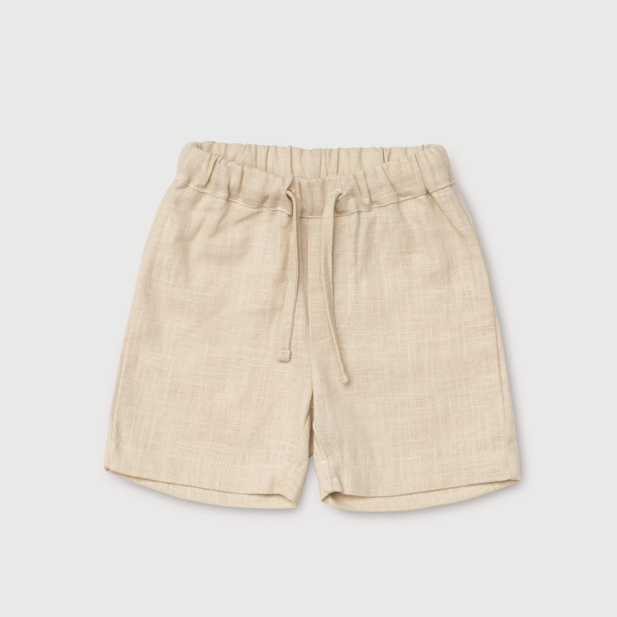 Front view of short beige linen pants for babies and toddlers with elastic waistband and drawstring.