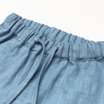 Close-up of the elastic waistband and drawstring on short blue linen pants for babies and toddlers.
