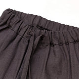 Close-up of the elastic waistband and drawstring on short brown linen pants for babies and toddlers.