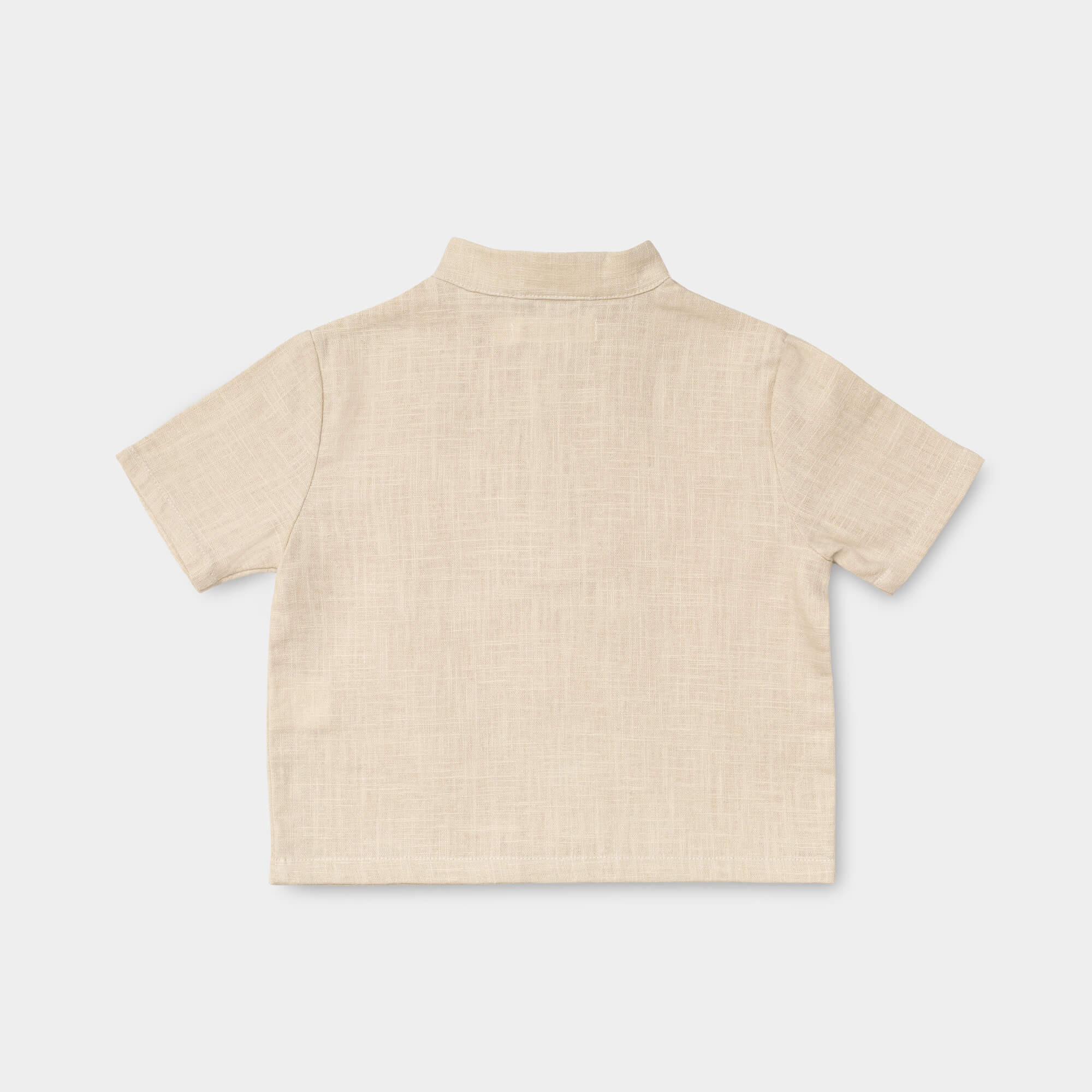 Back view of a lightweight beige linen short-sleeve shirt for babies and toddlers.