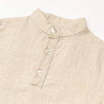 Close-up of the collar and buttons on a beige linen short-sleeve shirt for babies and toddlers.