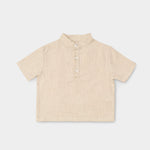 Front view of a short-sleeve beige linen shirt for babies and toddlers with a three-button placket.