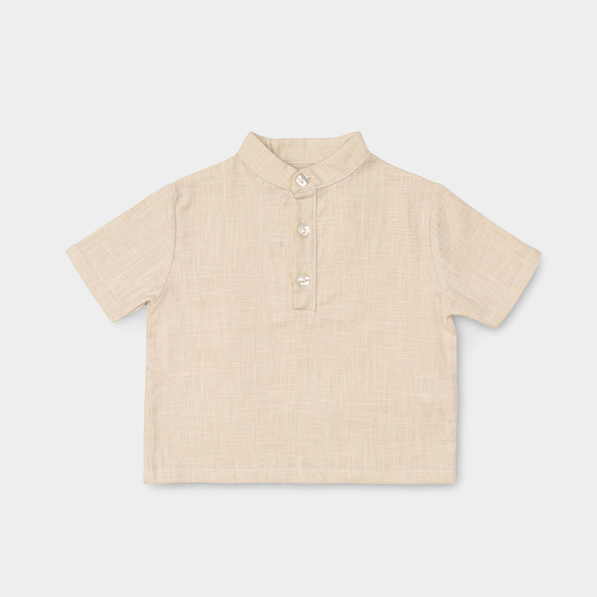 Front view of a short-sleeve beige linen shirt for babies and toddlers with a three-button placket.