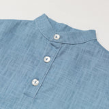 Close-up of the collar and buttons on a blue linen short-sleeve shirt for babies and toddlers.