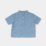 Front view of a short-sleeve blue linen shirt for babies and toddlers with a three-button placket.