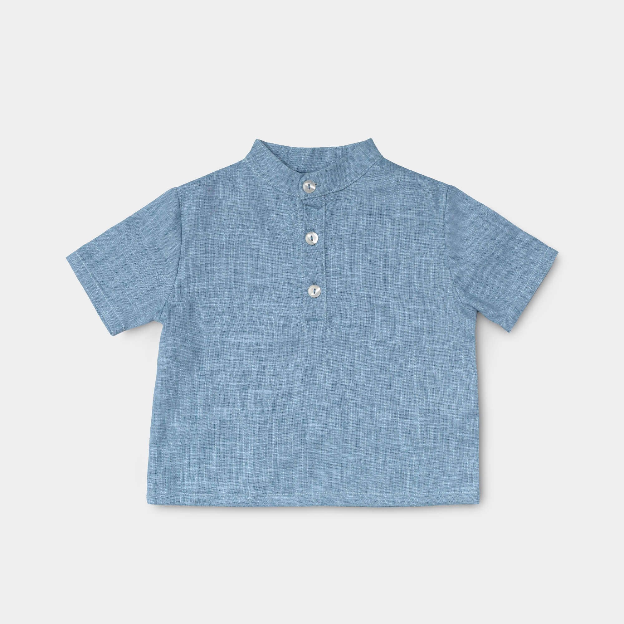 Front view of a short-sleeve blue linen shirt for babies and toddlers with a three-button placket.