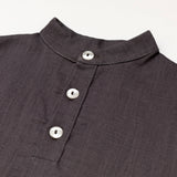 Close-up of the collar and buttons on a brown linen short-sleeve shirt for babies and toddlers.