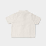 Back view of a lightweight white linen short-sleeve shirt for babies and toddlers.