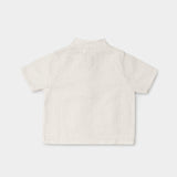 Back view of a lightweight white linen short-sleeve shirt for babies and toddlers.