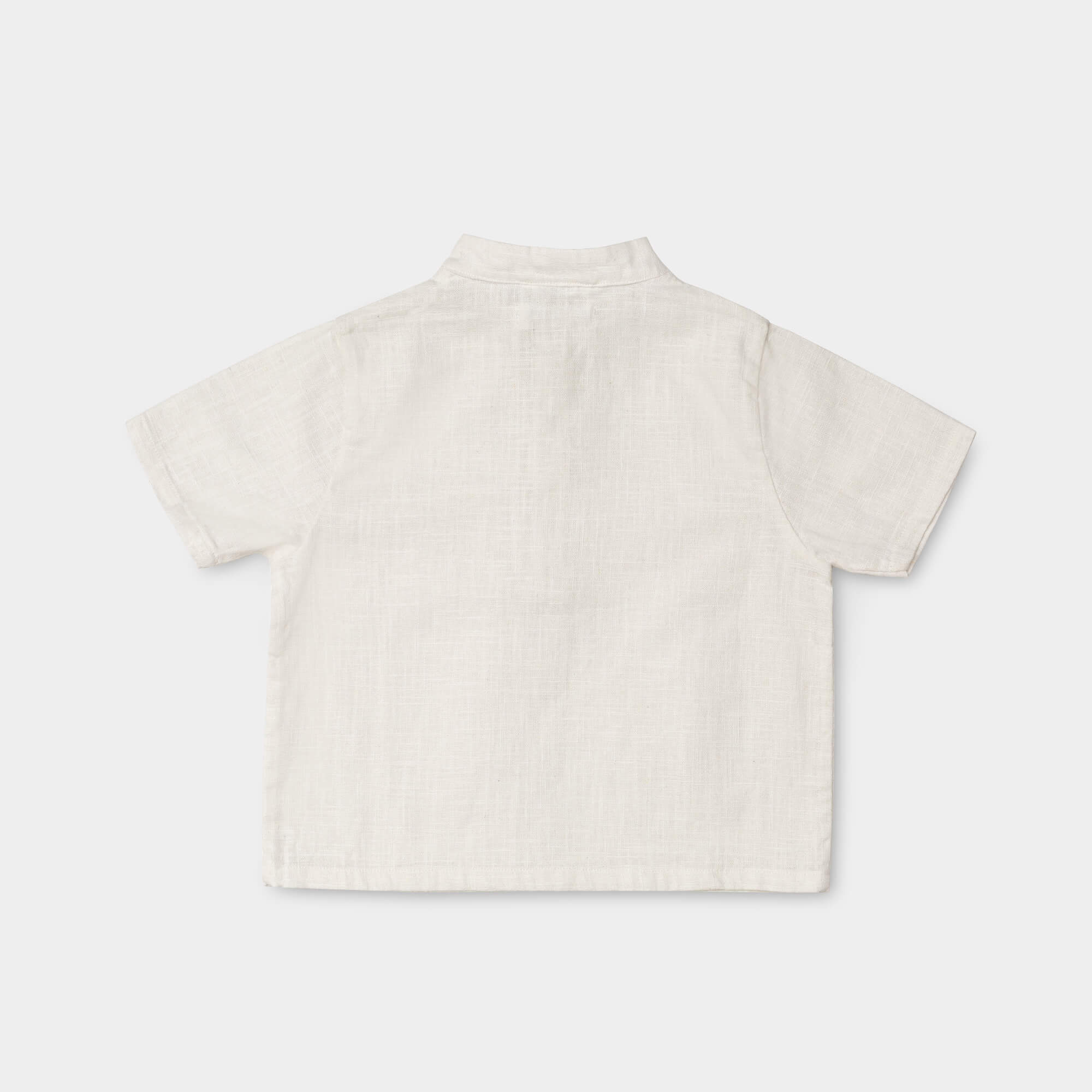 Back view of a lightweight white linen short-sleeve shirt for babies and toddlers.