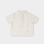 Front view of a short-sleeve white linen shirt for babies and toddlers with a three-button placket.