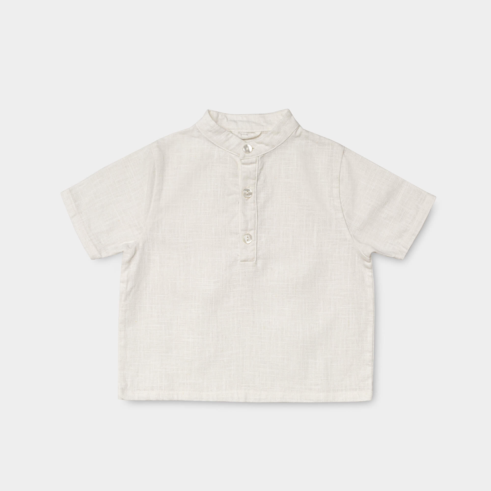 Front view of a short-sleeve white linen shirt for babies and toddlers with a three-button placket.