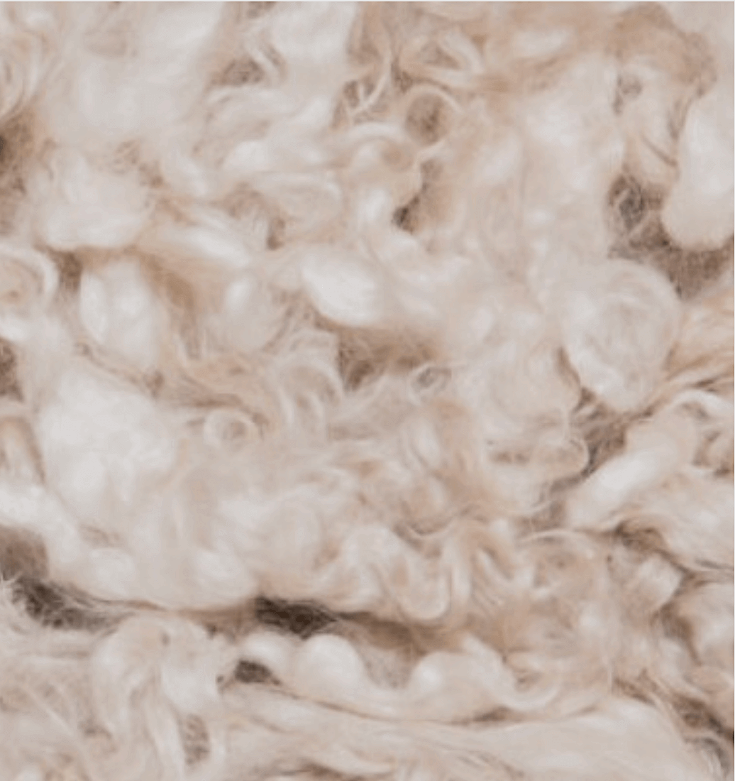 Close-up texture of soft cream cashmere wool used in baby clothing