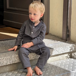 Toddler wearing soft brown long linen pants and matching top.
