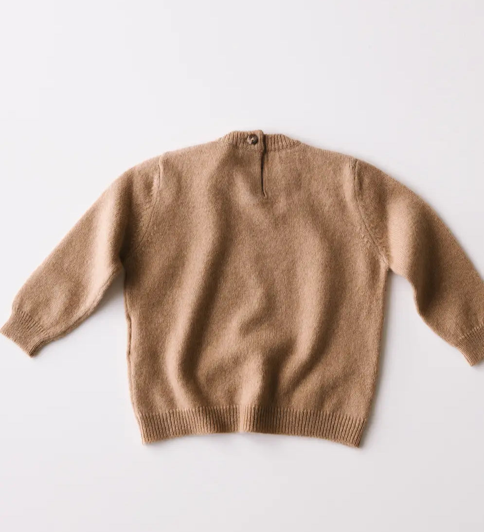 Caramel brown baby cashmere sweater shown from the back on a white background.