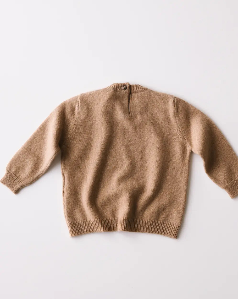 Caramel brown baby cashmere sweater shown from the back on a white background.