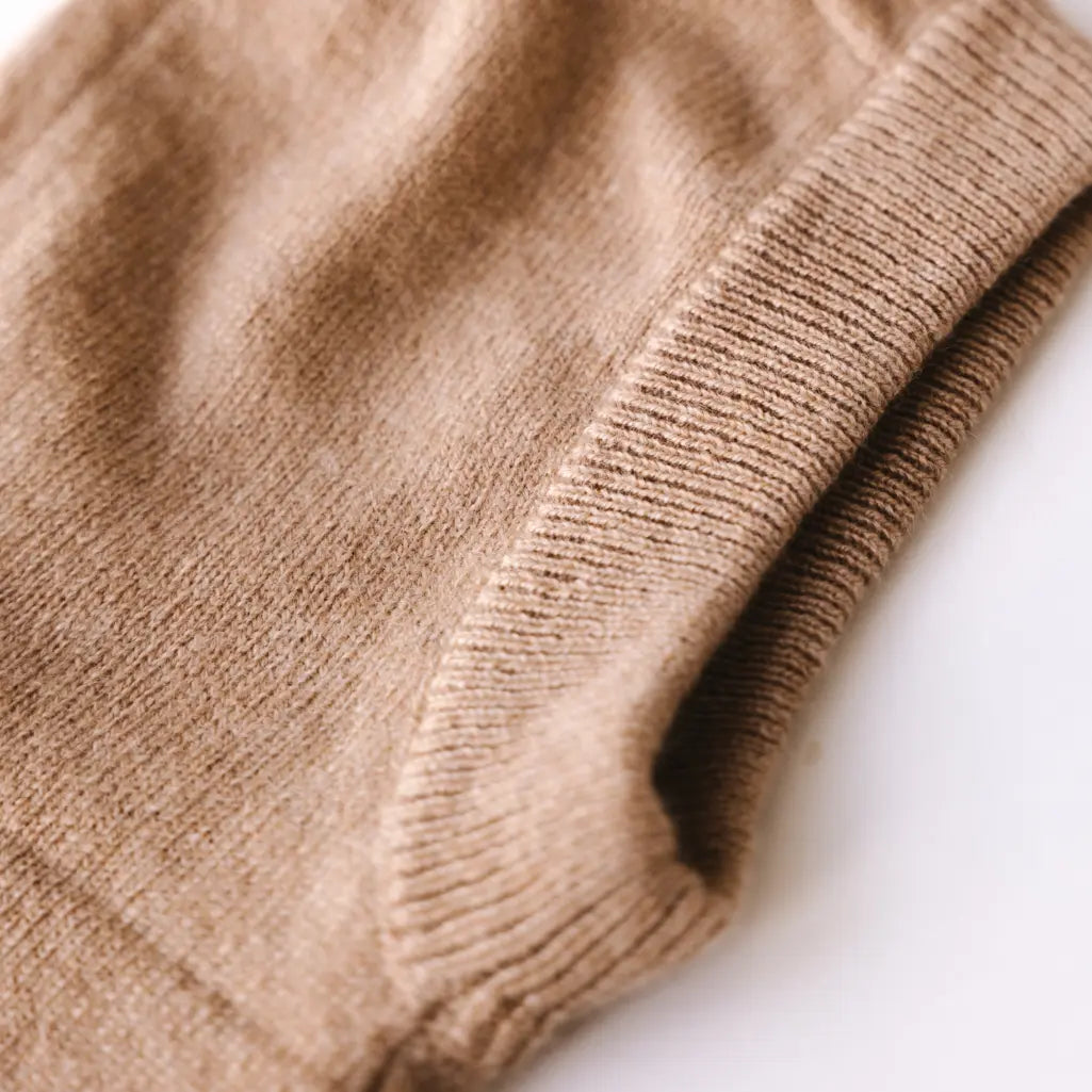 Close-up of caramel brown cashmere knit balaclava showing soft texture and ribbed edge.