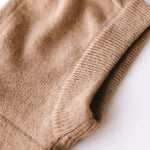 Close-up of caramel brown cashmere knit balaclava showing soft texture and ribbed edge.