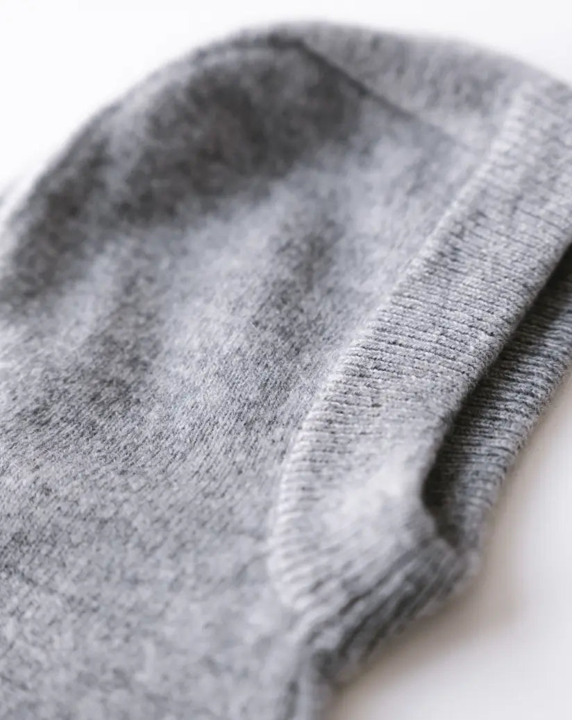 Close-up of heather grey cashmere knit balaclava showing soft texture and ribbed edge.