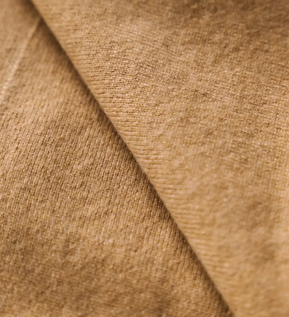 Close-up of the soft caramel brown cashmere fabric showing its fine texture.