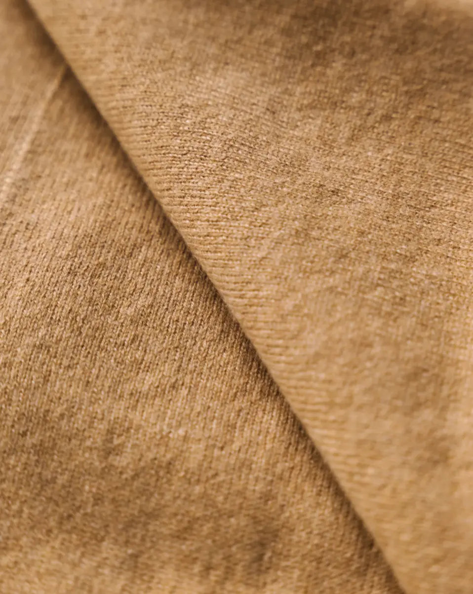 Close-up of the soft caramel brown cashmere fabric showing its fine texture.