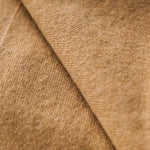 Close-up of the soft caramel brown cashmere fabric showing its fine texture.