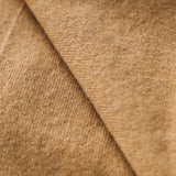 Close-up of the soft caramel brown cashmere fabric showing its fine texture.