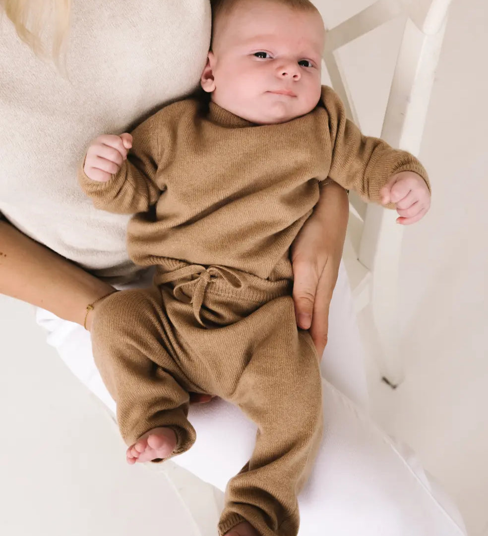 Baby wearing caramel brown cashmere pants with matching knitwear set.