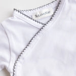 Close-up of the crochet detail on the grey baby bodysuit